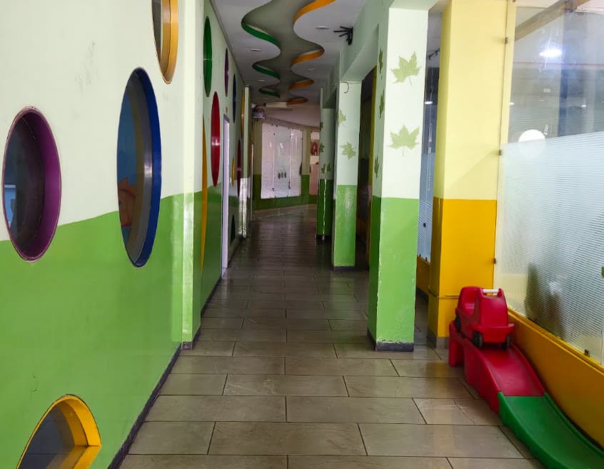 AIS Kindergarten corridor — bright colours, porthole windows, and play equipment