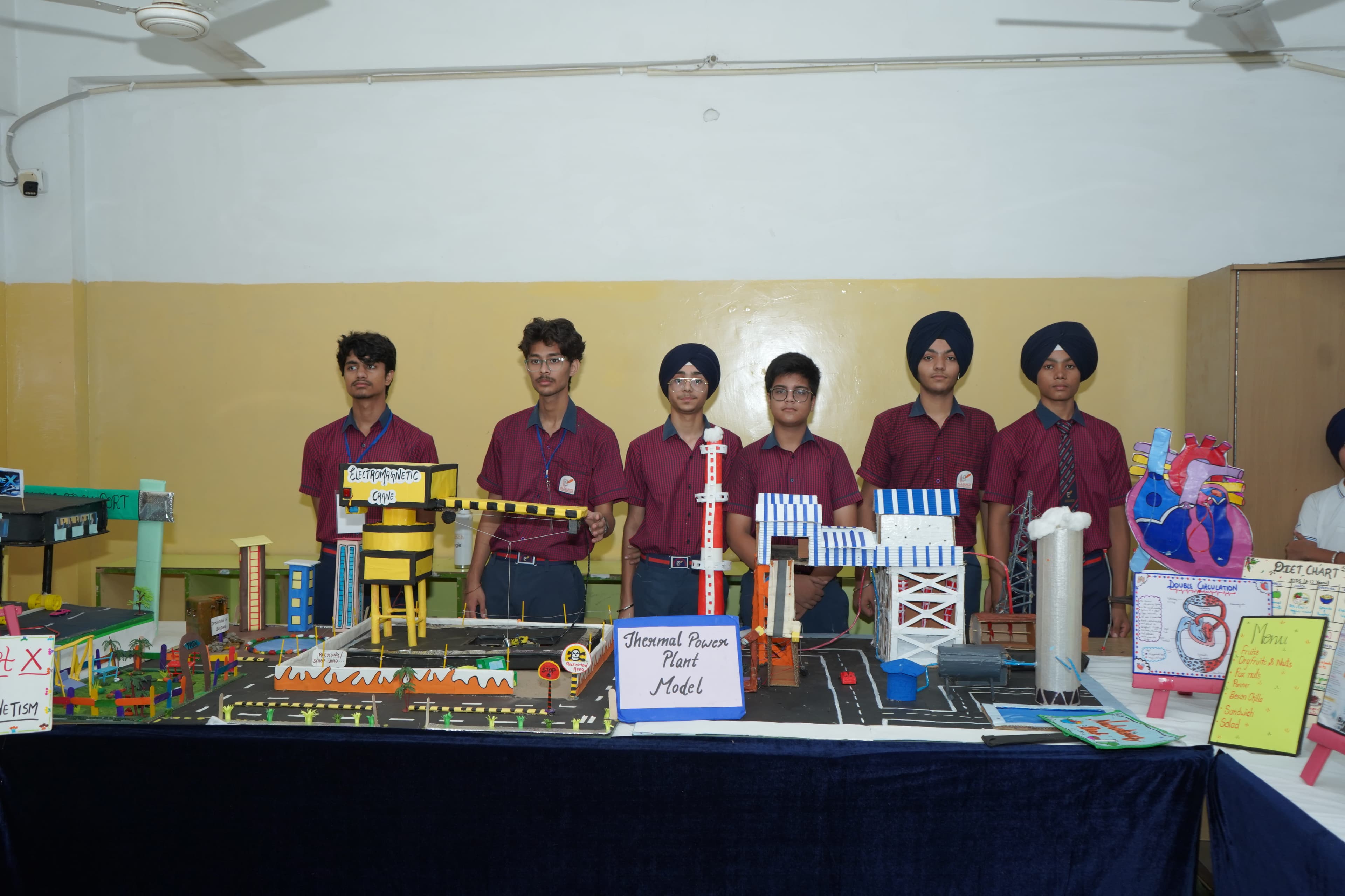 AIS students displaying a thermal power plant model